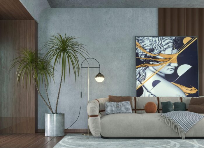 Modern living room with a gray sofa adorned with various pillows. A large abstract art piece hangs on the wall. A tall potted plant and floor lamp add style.