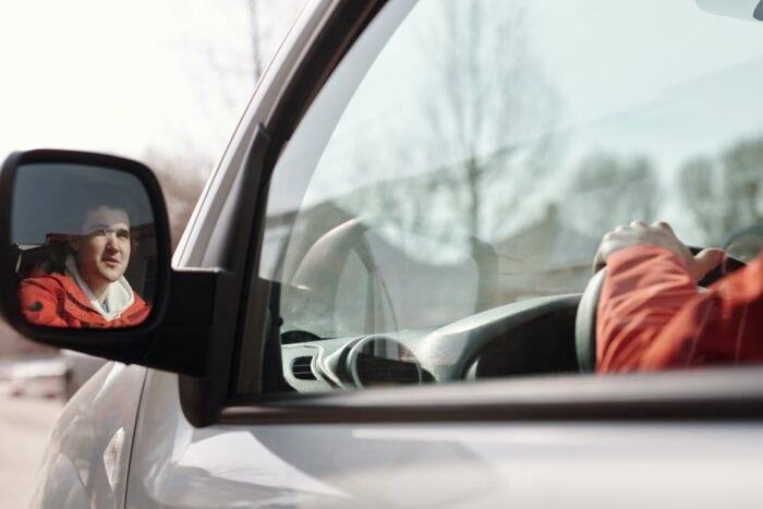 Photo by Norma Mortenson: https://www.pexels.com/photo/man-in-red-and-white-hoodie-sitting-on-car-seat-4391220/