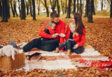 5 Outdoor Activities to Plan for an Unforgettable Valentine’s Day Family of four enjoys an autumn picnic on a blanket, surrounded by colorful leaves. They wear red sweaters, creating a warm, joyful atmosphere.