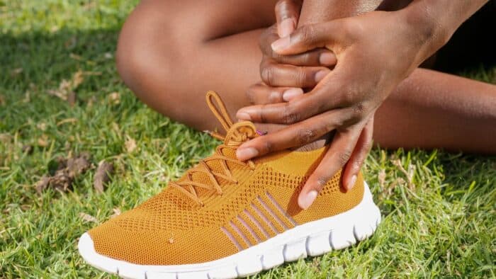 Photo by Kindel Media: https://www.pexels.com/photo/a-person-s-hands-holding-ankle-7298647/