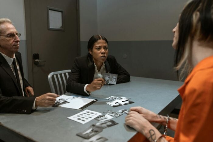 Photo by RDNE Stock project: https://www.pexels.com/photo/woman-in-black-jacket-sitting-on-chair-interrogating-an-inmate-6065466/
