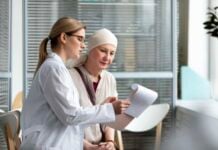 Finding Clarity in the Storm: Why a Second Opinion Matters in Cancer Care A female doctor in a white coat explains medical documents to a patient wearing a headscarf, in a bright clinic. The atmosphere is calm and supportive.