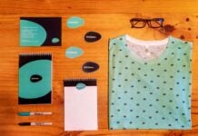 5 Benefits of Having Branded Apparel for Your Business A flatlay of a collection of branded apparel on a wooden table.
