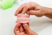 Reclaiming Your Smile: Tips for Buying High-Quality Dentures Online Two hands holding a set of pink and white dental dentures on a bright, clean surface, conveying a clinical and educational tone.