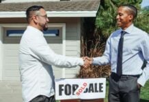 The Hidden Value of Talking to the Neighbors Before You Buy a House Two men shake hands outside a house beside a “SOLD” real estate sign, suggesting a successful sale in a bright, friendly outdoor scene.