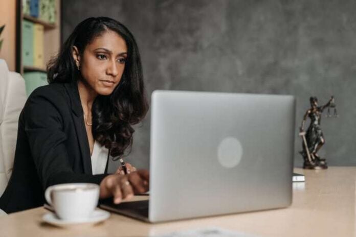 https://www.pexels.com/photo/woman-in-suit-sitting-and-working-on-laptop-8111864/